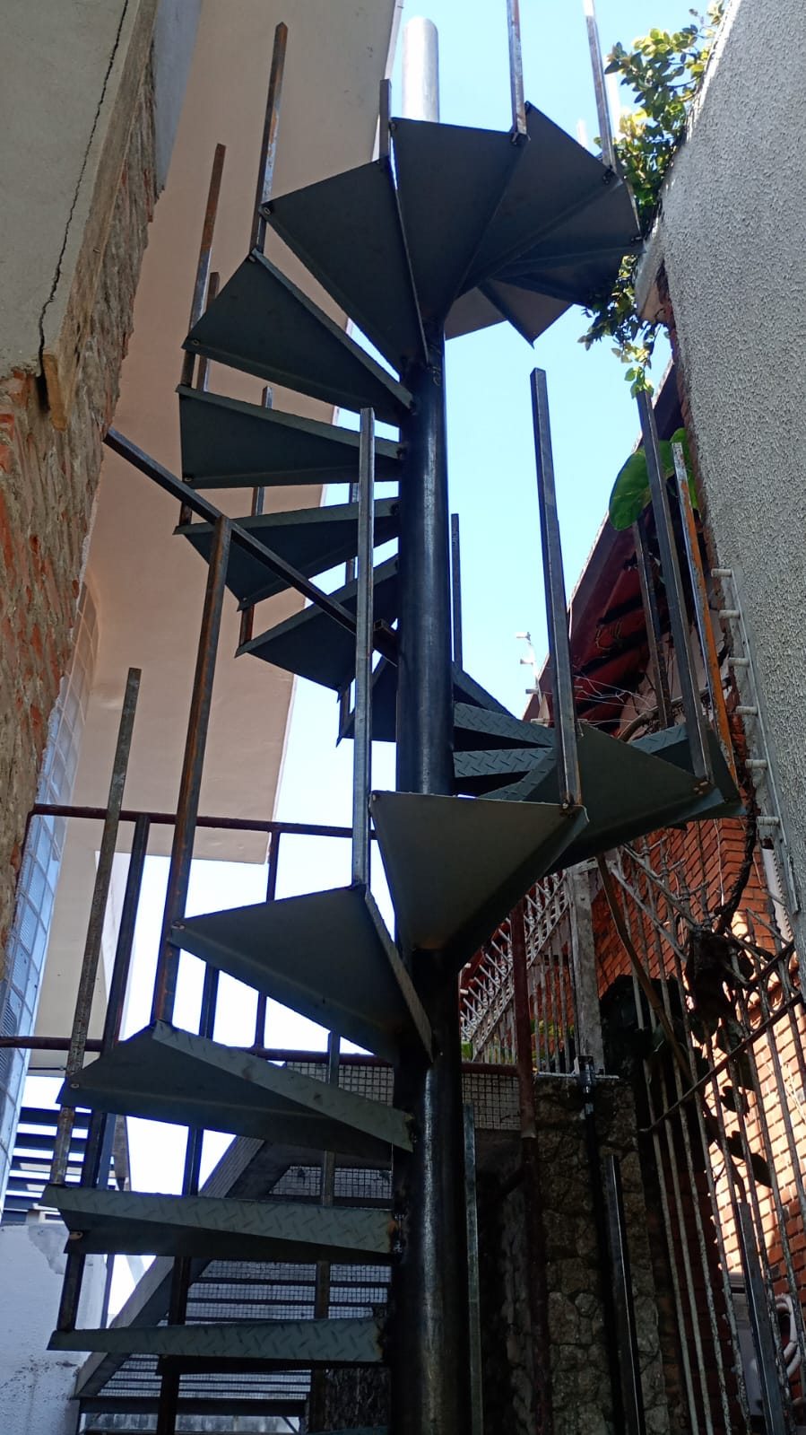 Escada caracol metálica vista de baixo entre paredes